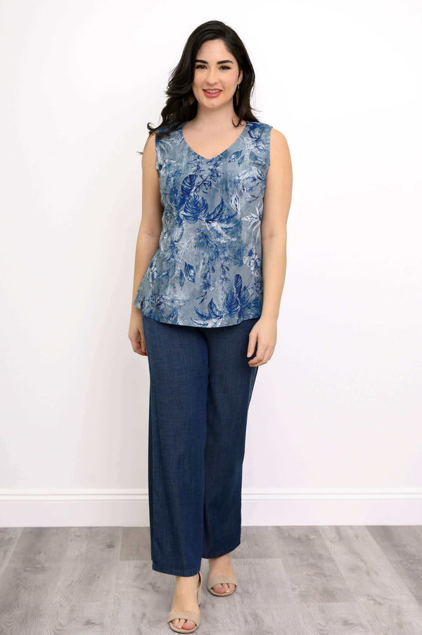 Woman modeling blue floral V-neck sleeveless top standing straight