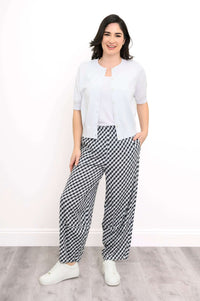 Model styled in short-sleeve white cardigan and black gingham wide-leg pants