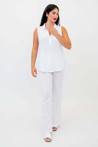 Woman walking in white sleeveless tank top and matching pants