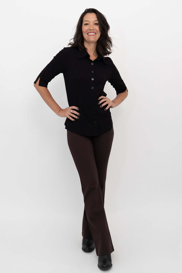 Model smiling and wearing Daya Flared Modal Pants in coffee with a black button-down top