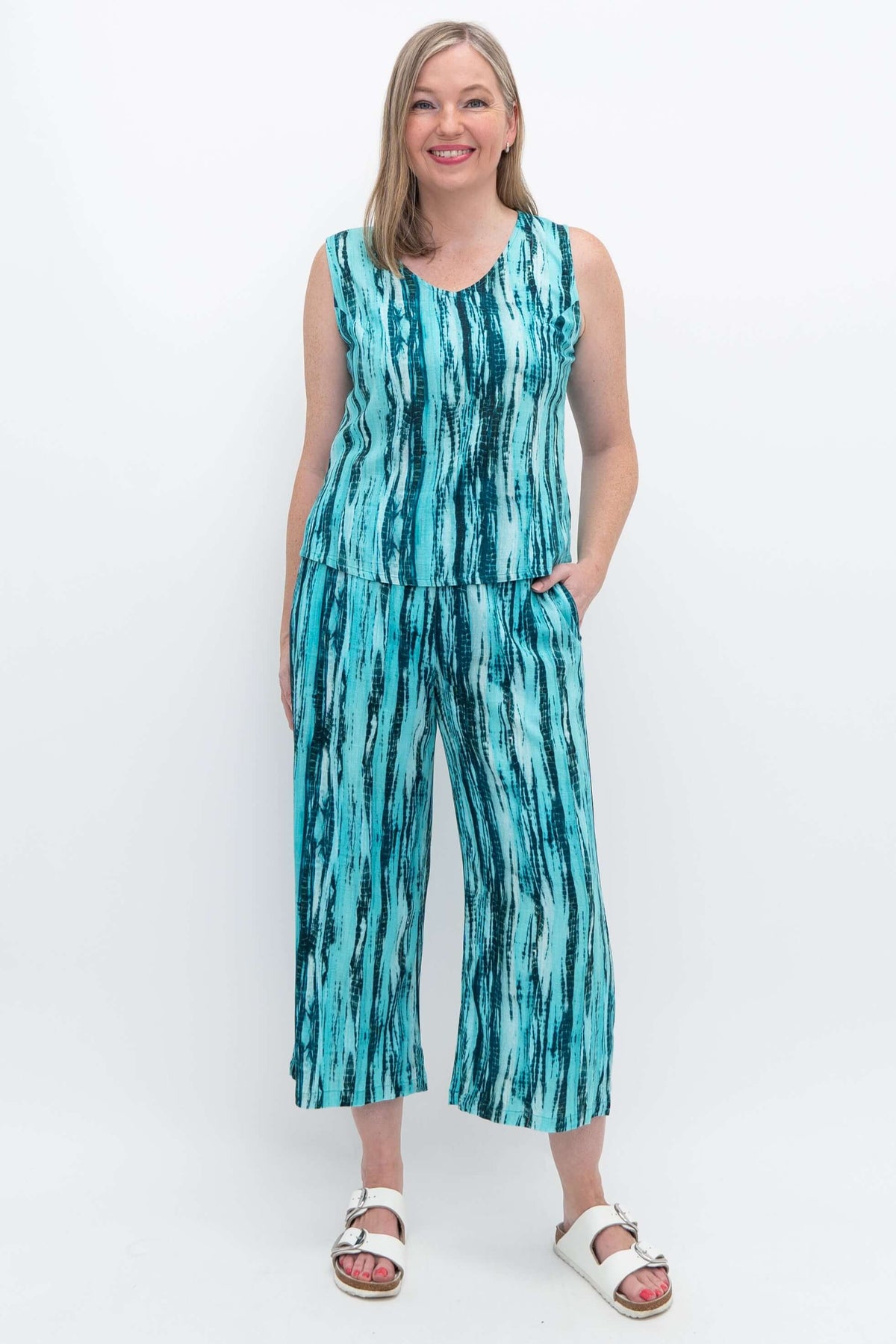 Model wearing Landon Capri Pants and matching sleeveless top in blue striped pattern