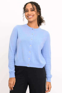 Model wearing a light blue cashmere cardigan with button-front closure