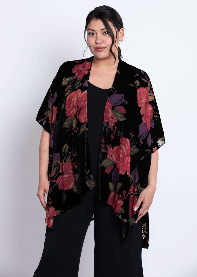 Model wearing a black velvet kimono with bold red and purple floral print