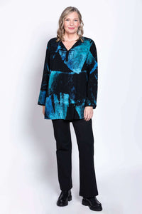 Model standing in blue and black batik blouse and black pants, hands at side