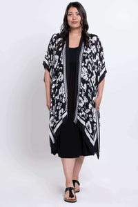 Model wearing floral kimono wrap, standing with sandals