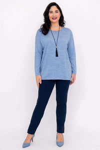 Woman with dark hair modeling a light blue long sleeve sweater and navy pants