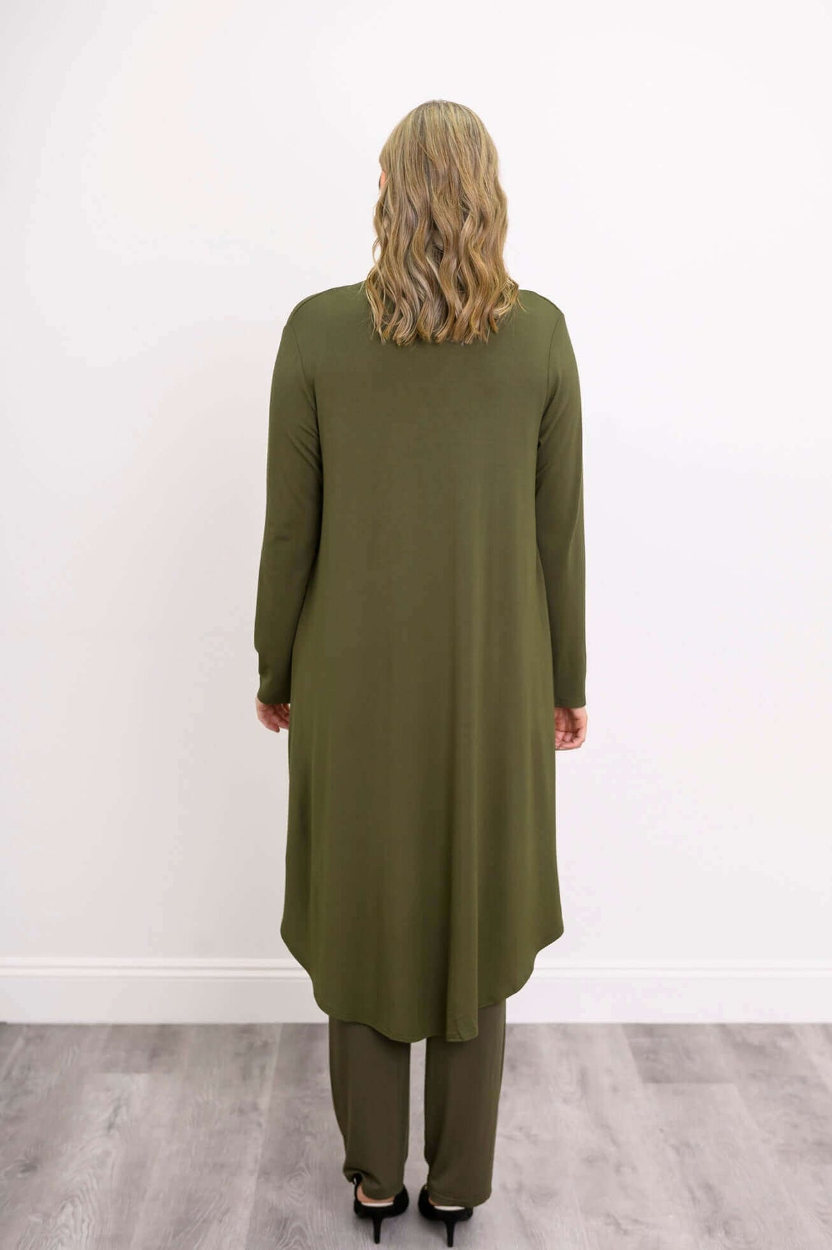 Model in olive green duster cardigan over wide-leg pants and a scoop neck top