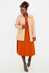 Model in tan Chanel Cardigan with front open, showing matching orange dress and taupe boots
