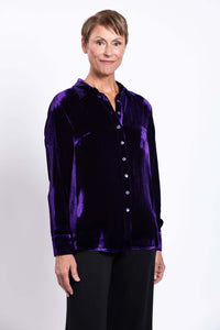 Woman posing in purple silk velvet blouse with button cuffs and collar