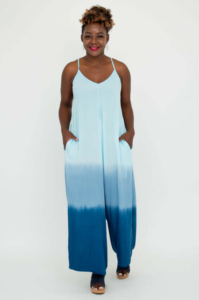 Model standing with hands in pockets, showcasing a blue tie-dye jumpsuit