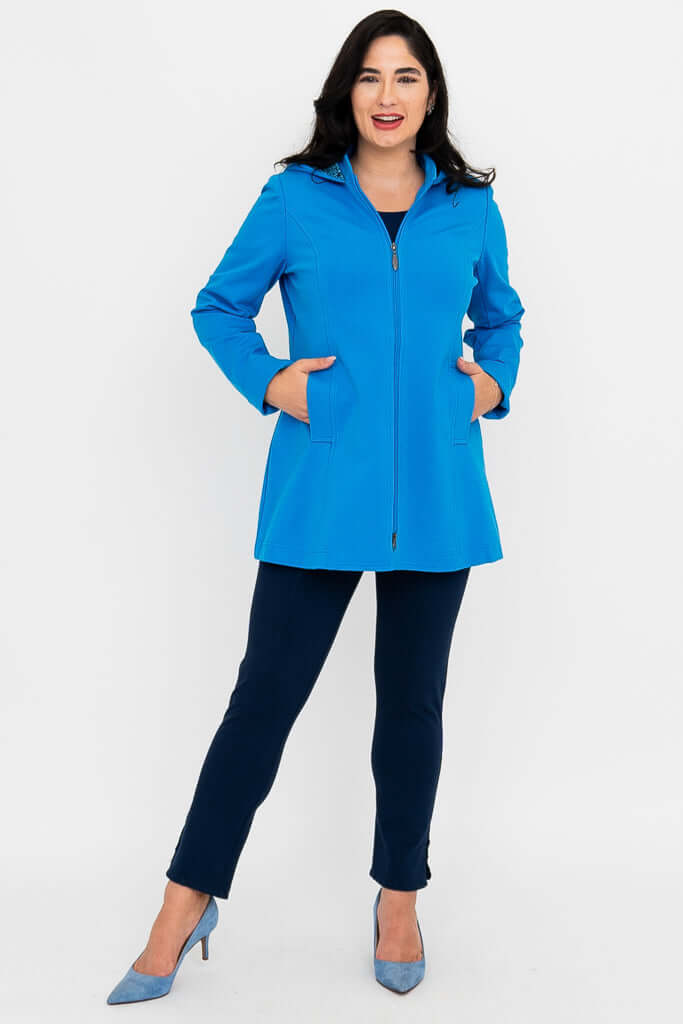 Woman with hands in pockets, modeling zipped bright blue coat