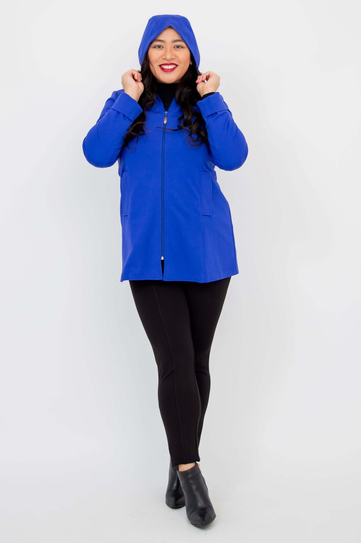 Model with hood up, wearing royal blue Highlands Coat with front zipper