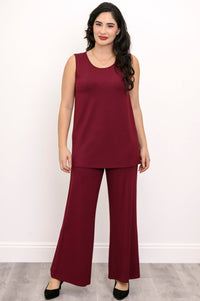 Straight-on full body portrait of an elegant women's wine red tank top and matching loose-fit knit pants.
