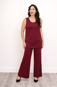 Wide studio shot of a relaxed-fit burgundy bamboo French terry sleeveless top styled with monochrome trousers.