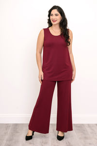 Full-length front view of a woman styling a burgundy sleeveless tank top with matching wide-leg trousers.