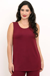 Front view of a smiling woman wearing a scoop neck burgundy sleeveless tank top.