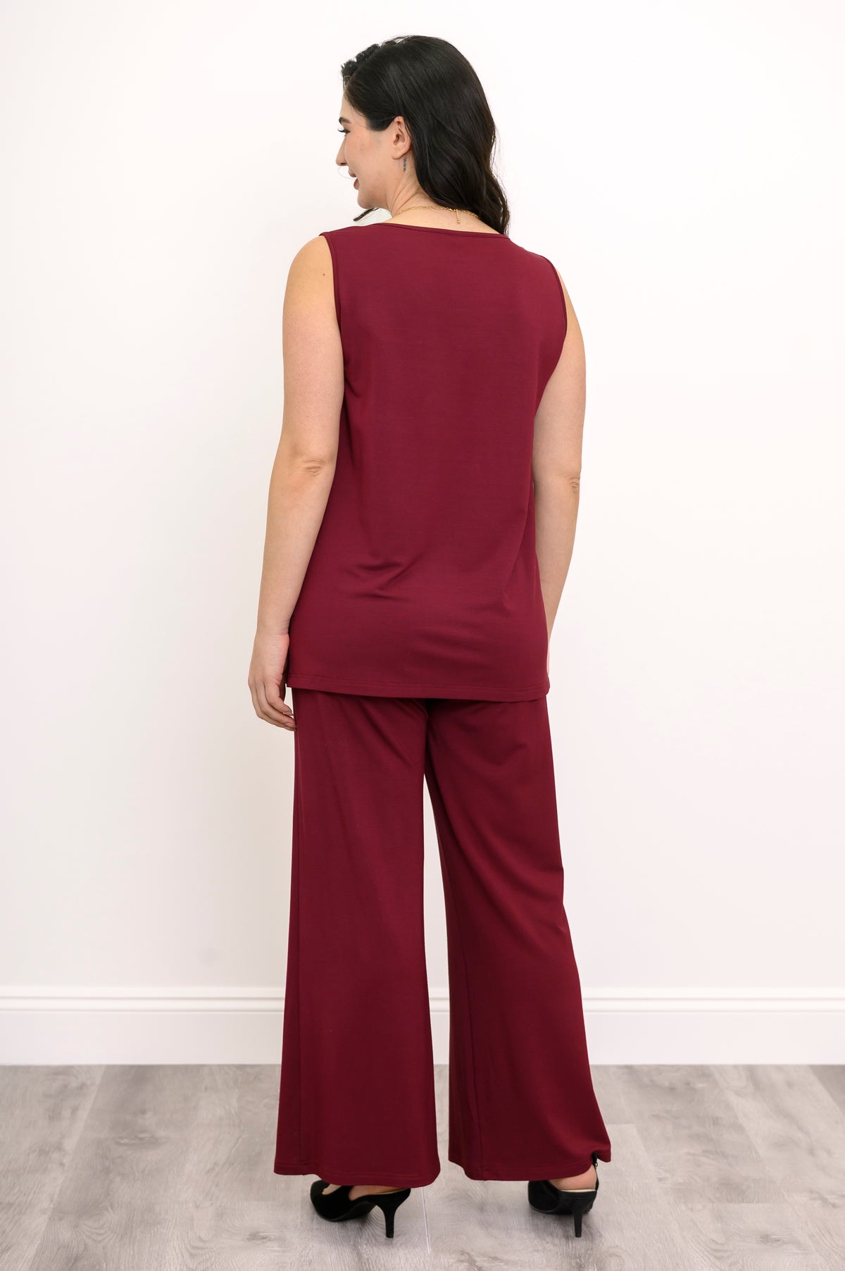 Back view of a woman wearing a burgundy sleeveless knit tank top paired with matching wide-leg pants.