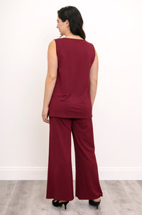 Back view of a woman wearing a burgundy sleeveless knit tank top paired with matching wide-leg pants.