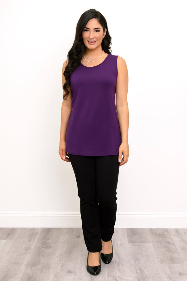 Front view of a female model wearing a French Terry purple tank and black pants with black heels against a white backdrop and grey floor