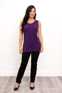 Front view of a female model wearing a French Terry purple tank and black pants with black heels against a white background and grey floor