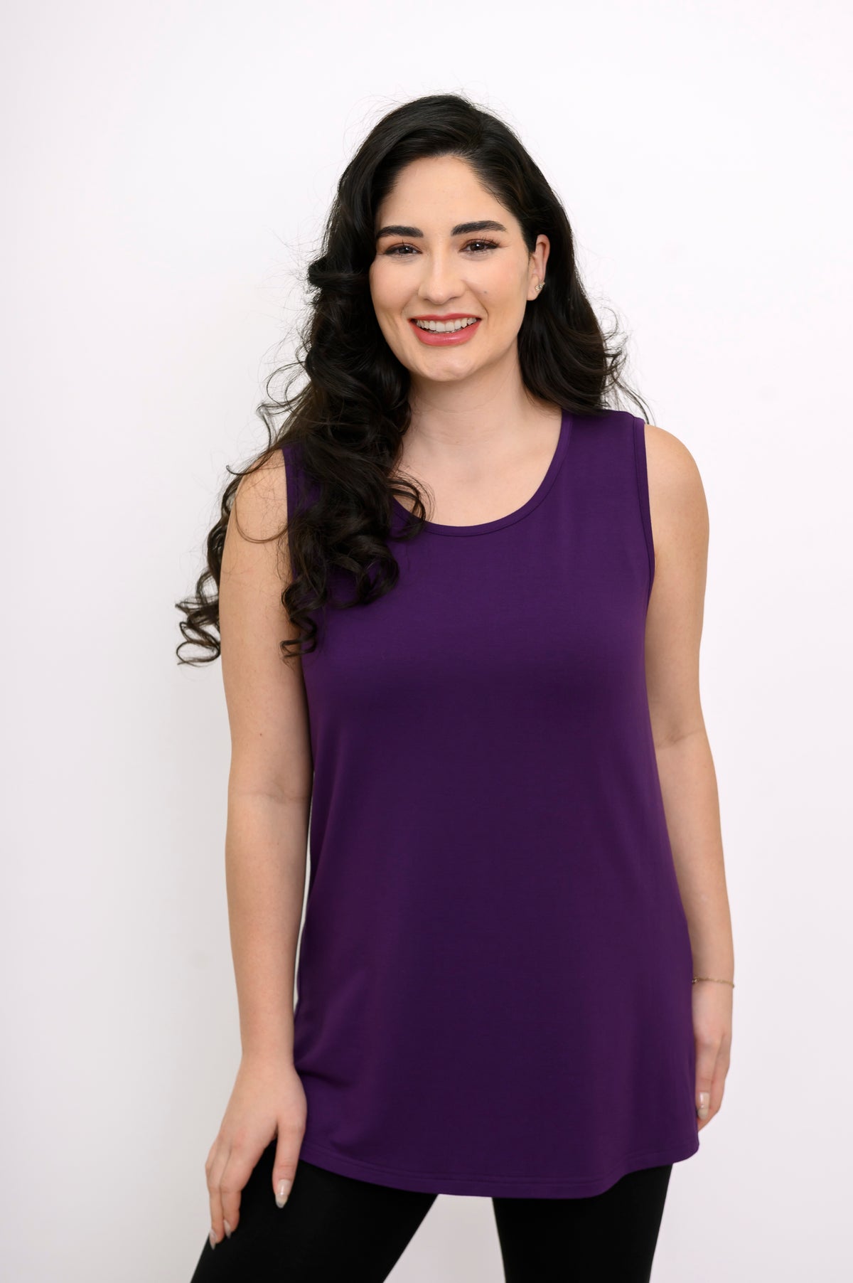Wide studio shot of a relaxed-fit purple sleeveless top creating a clean vertical silhouette over black trousers.