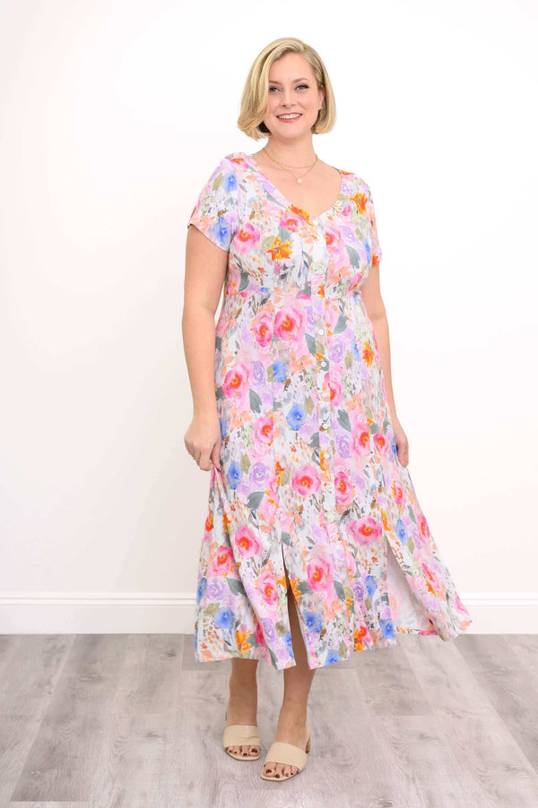 Model wearing a colourful floral button-front dress with cap sleeves and slits