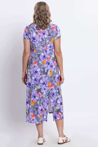 Back view of a woman wearing a purple floral print Morgan dress with back slit