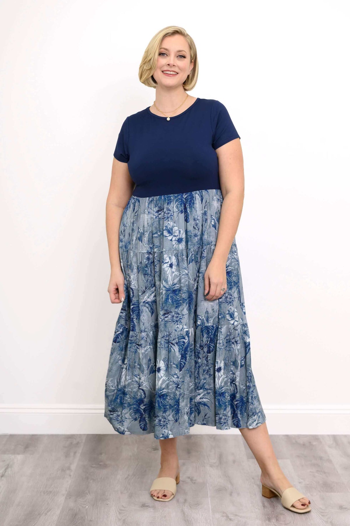 Woman posing in a navy and blue floral print empire waist maxi dress