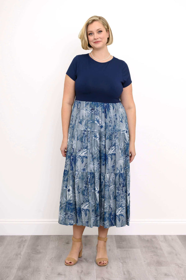 Woman wearing a navy blue and blue floral print empire waist maxi dress