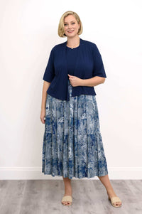 Woman wearing a navy blue cardigan over a blue floral print empire waist maxi dress