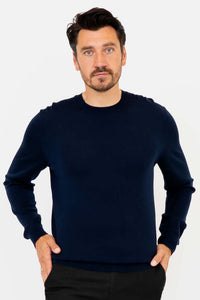Man wearing a navy blue merino wool sweater with hands in pockets, front view