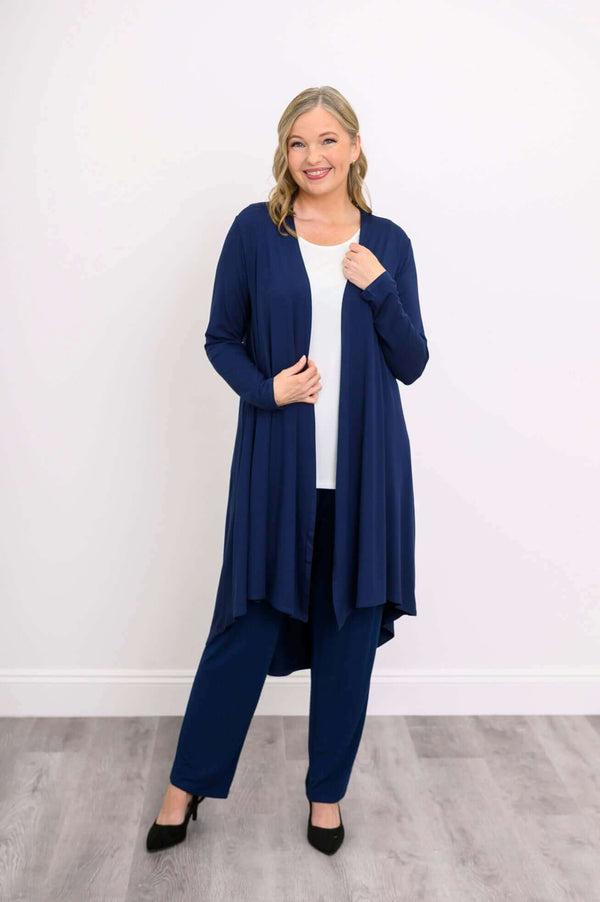 Woman wearing a navy blue open front duster cardigan and trousers, smiling and posing