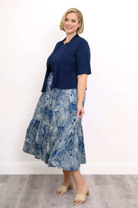 Woman in motion wearing a navy cardigan and blue floral print maxi dress