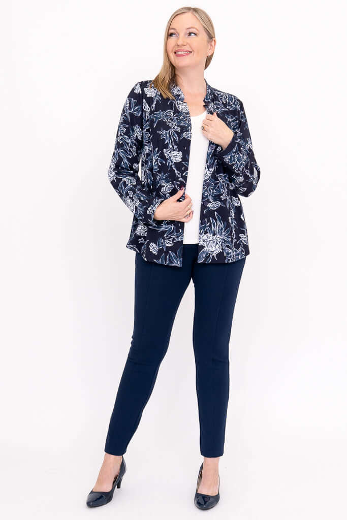 Model posing in open navy floral blouse with white shirt and navy pants