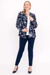 Model posing in open navy floral blouse with white shirt and navy pants