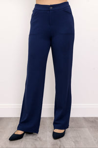 Woman wearing navy blue pants with pockets and navy blue shoes on a white background, front view