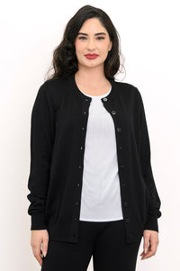 Studio portrait of a woman modeling a black long sleeve button down cardigan over a white shirt.