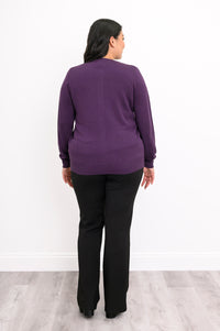 Back view of a woman wearing a hip length amethyst purple cotton viscose knit cardigan in studio.