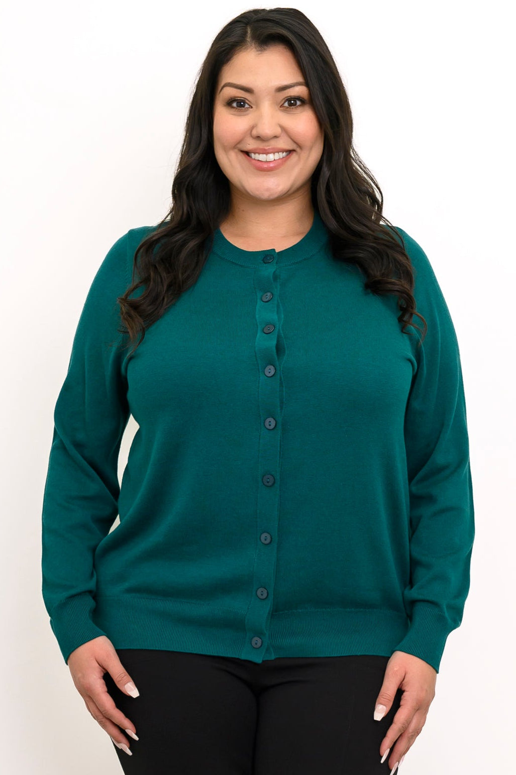 Close up front view of a woman wearing an emerald green crewneck button up cotton knit cardigan.
