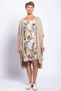 Older woman in swirl print dress layered with a light tan open cardigan