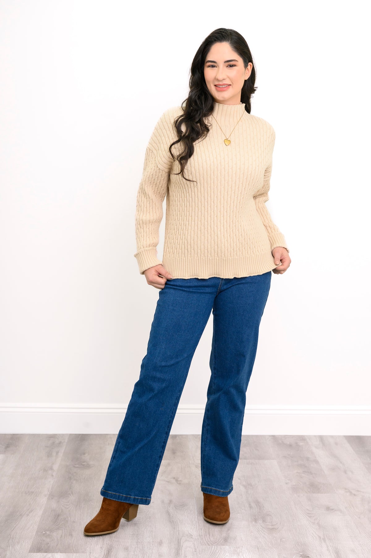 Comfortable cream-colored cotton sweater featuring a structured neckline, styled with blue jeans on a model.