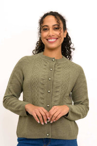 Woman wearing an olive green cable knit cashmere cardigan with pearl buttons, close-up view
