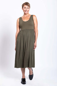 Smiling woman posing in olive green empire waist midi dress