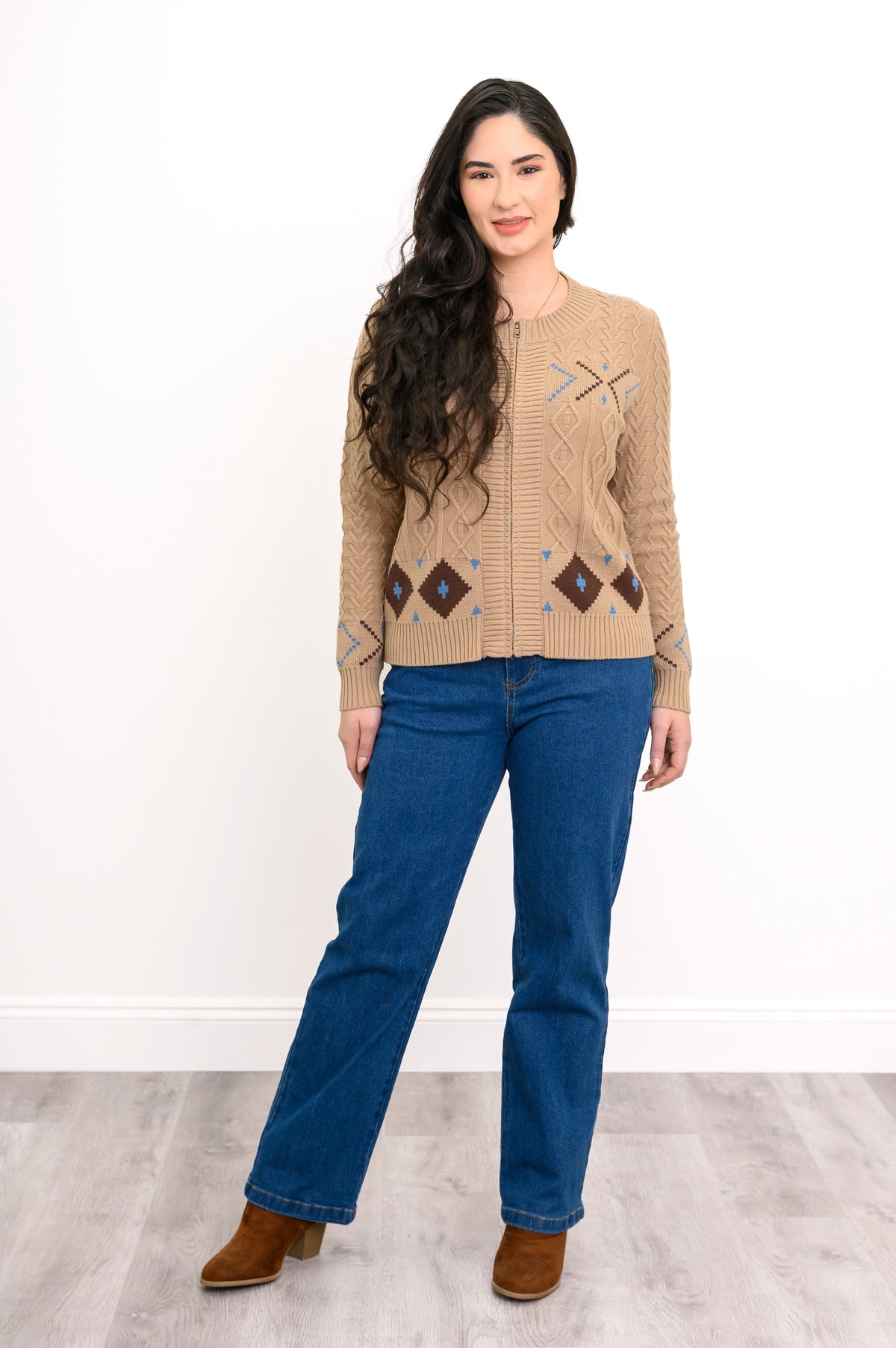 Angled view of a warm cream-colored zippered knit top, showcasing its retro patterns and structured fit.