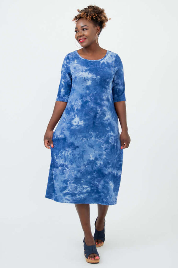 Woman modeling a blue bamboo tie dye dress with elbow length sleeves, walking pose