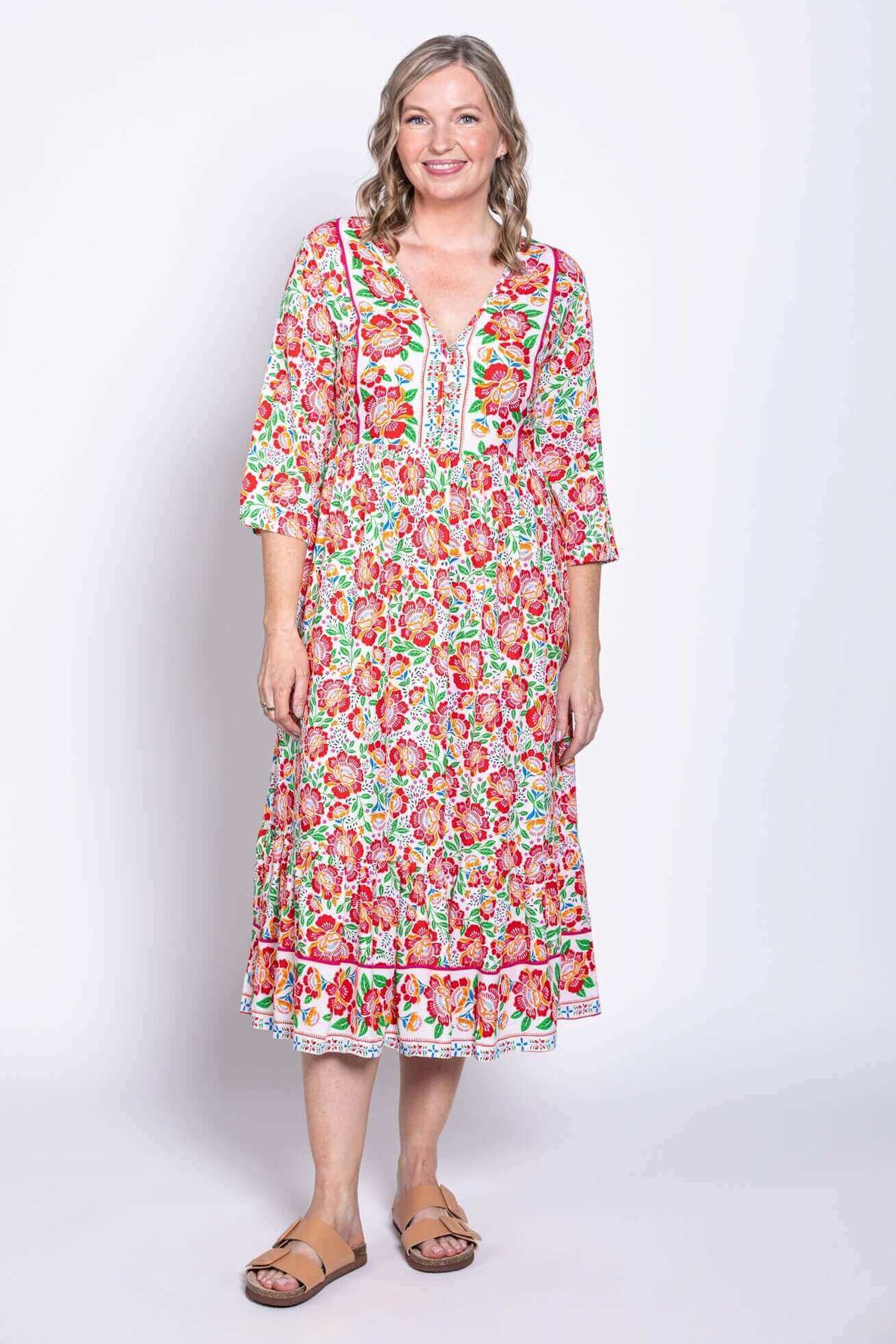 Front view of model wearing lightweight batik midi dress with colorful floral print