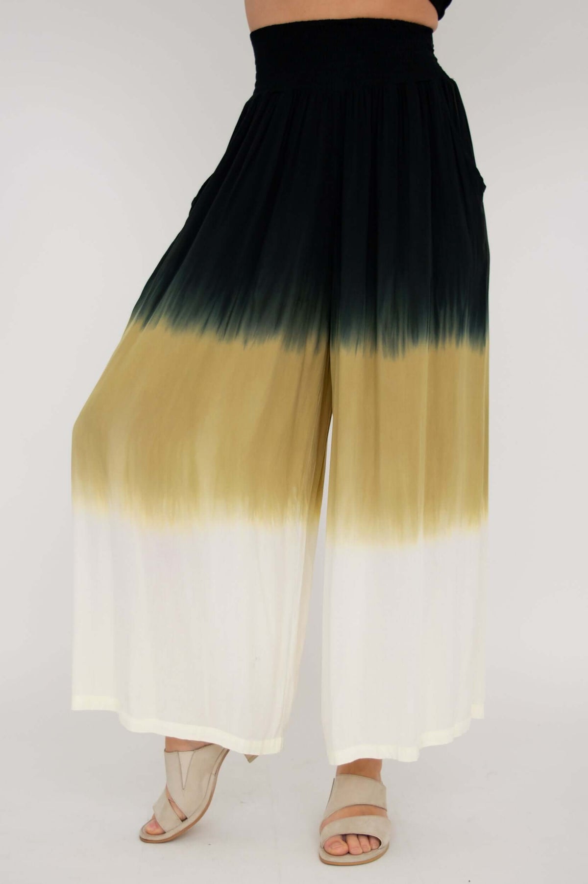 Angled front view showing flowy ombre boho pants in black, tan, and white
