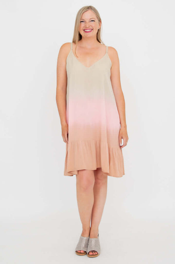 Woman wearing sleeveless ombre dress with adjustable straps and flounce hem, standing and smiling