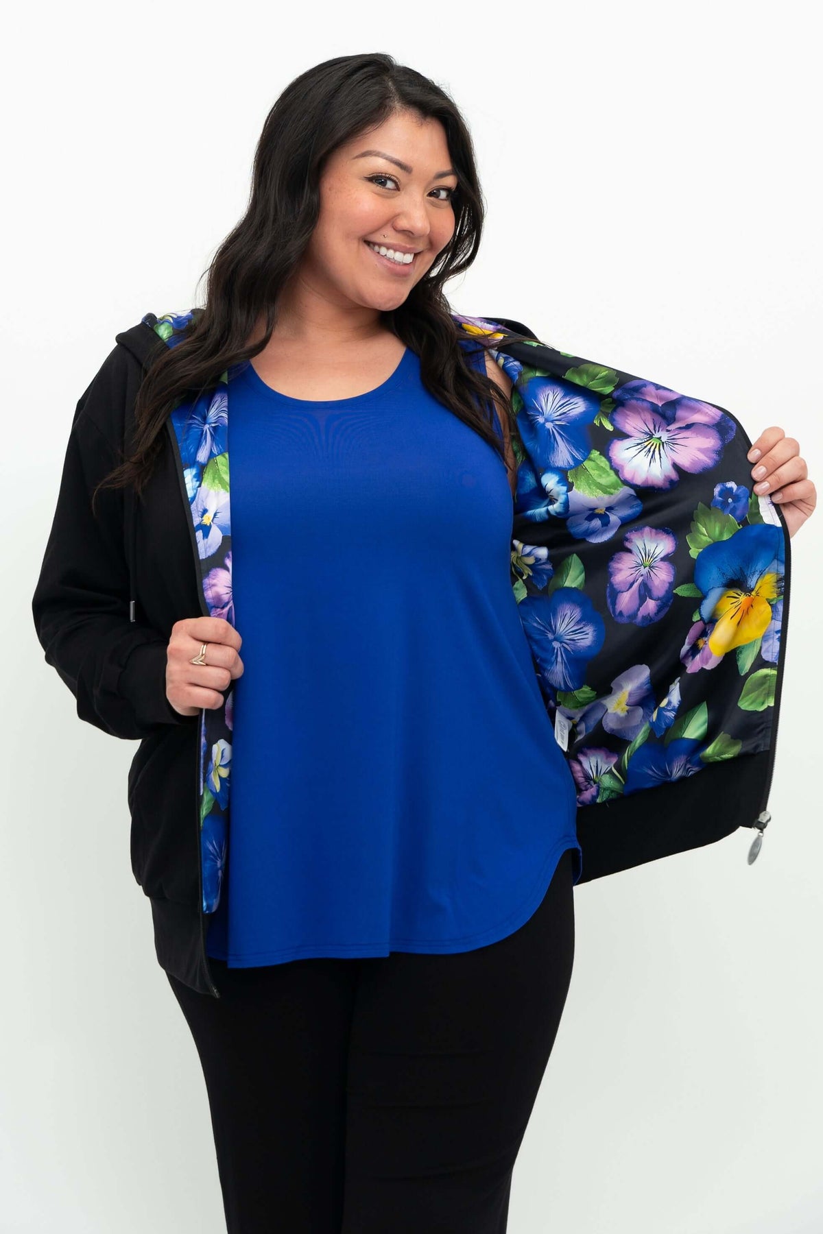 Woman revealing the vibrant floral print lining inside her black zip hoody