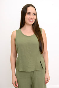 Woman wearing a green sleeveless top, wide-leg pants against, against a white background, front view